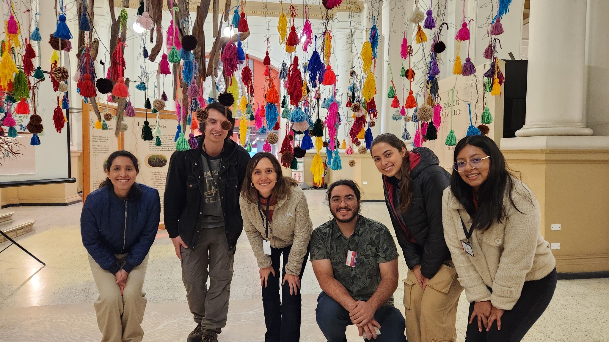 Participants at the Rizósfera Viviente exhibition at the Museo Nacional de Historia Natural, Santiago, surrounded by an immersive installation inspired by plant roots and the rhizosphere.